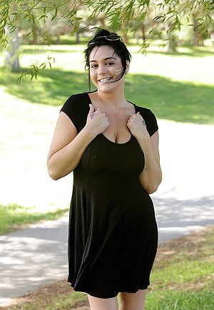 Brunette dressed in black showcasing her big soft breasts at the park